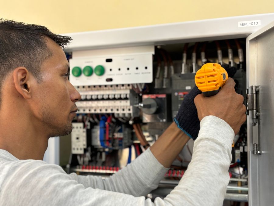 Electrician working on an electrical control panel