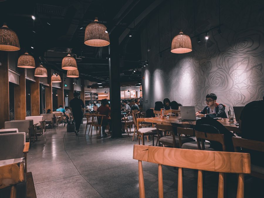 Warm restaurant dining room with wooden tables and pendant lighting